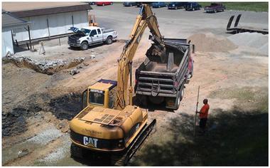 excavator loading dirt in dump truck